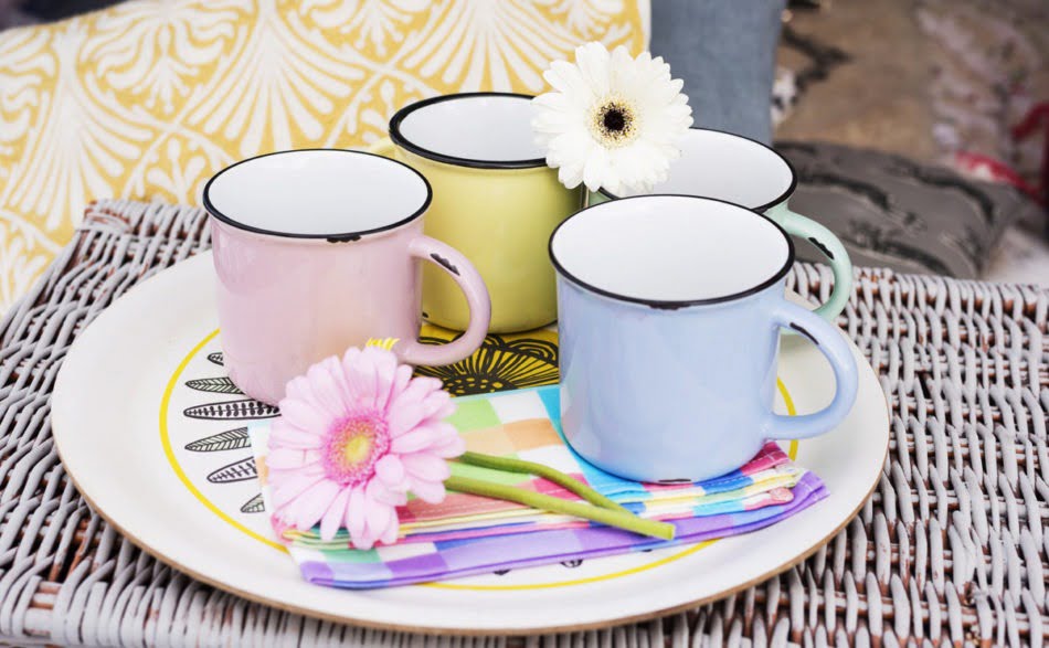 Interior Stylist + Home Blogger Maxine Brady gives her glamping guide - with tips on what to pack and ideas on where to stay. With a Nisi Living giveaway. A flower resting on top of colourful mugs