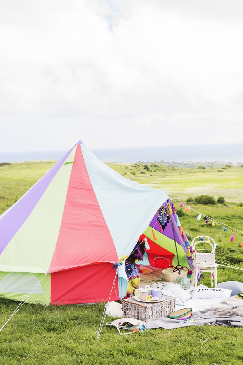 A colourful tent with the sea in the background