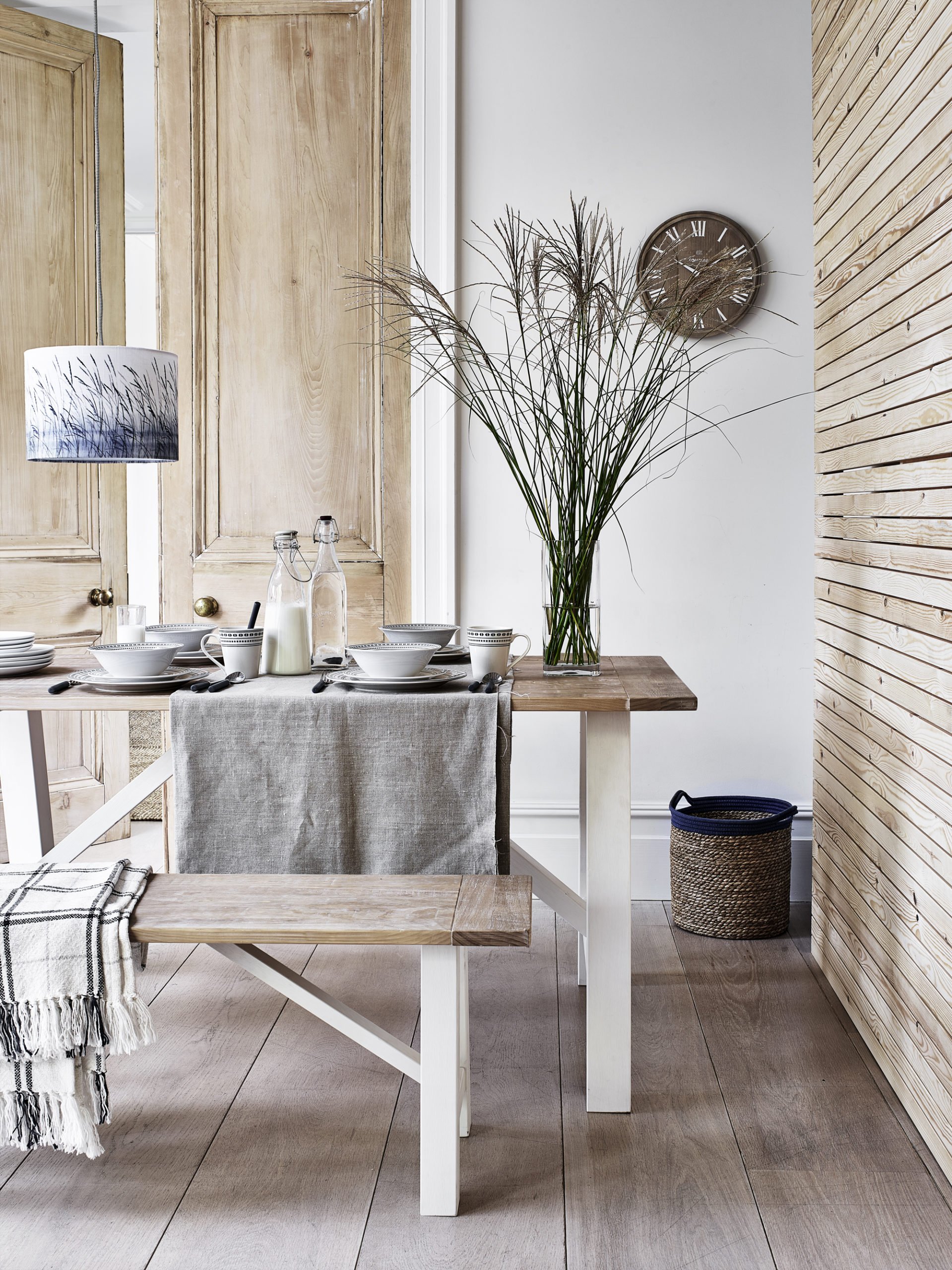 neutral rustic dining room with wooden table and bench - scandi style. Beach house.