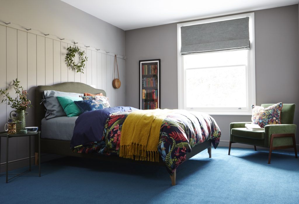 bedroom with blue carpet and painted panel wall, peg rail, green retro chair by Interior Stylist Maxine Brady