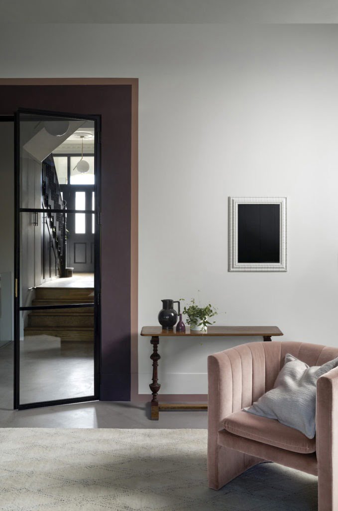 door lipstick painted living room with pink purple walls and velvet armchair